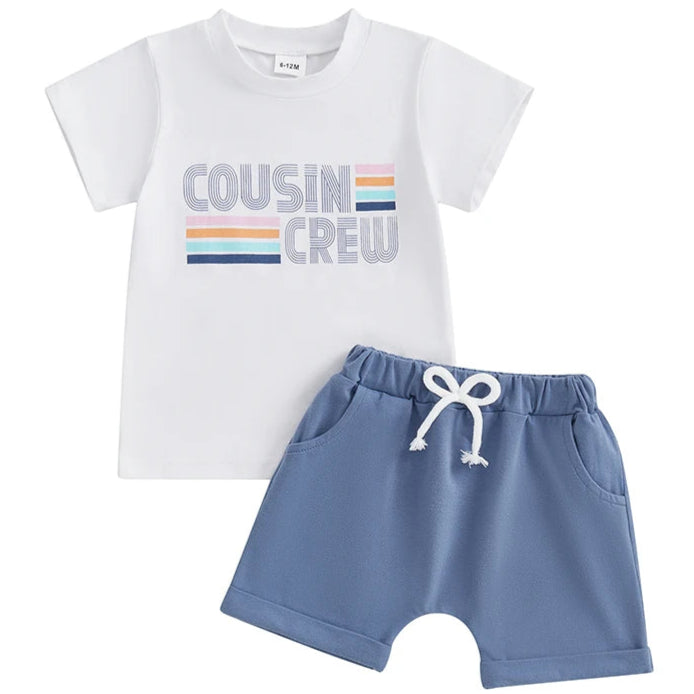 Flat lay of white baby tee with Cousin Crew print and blue shorts