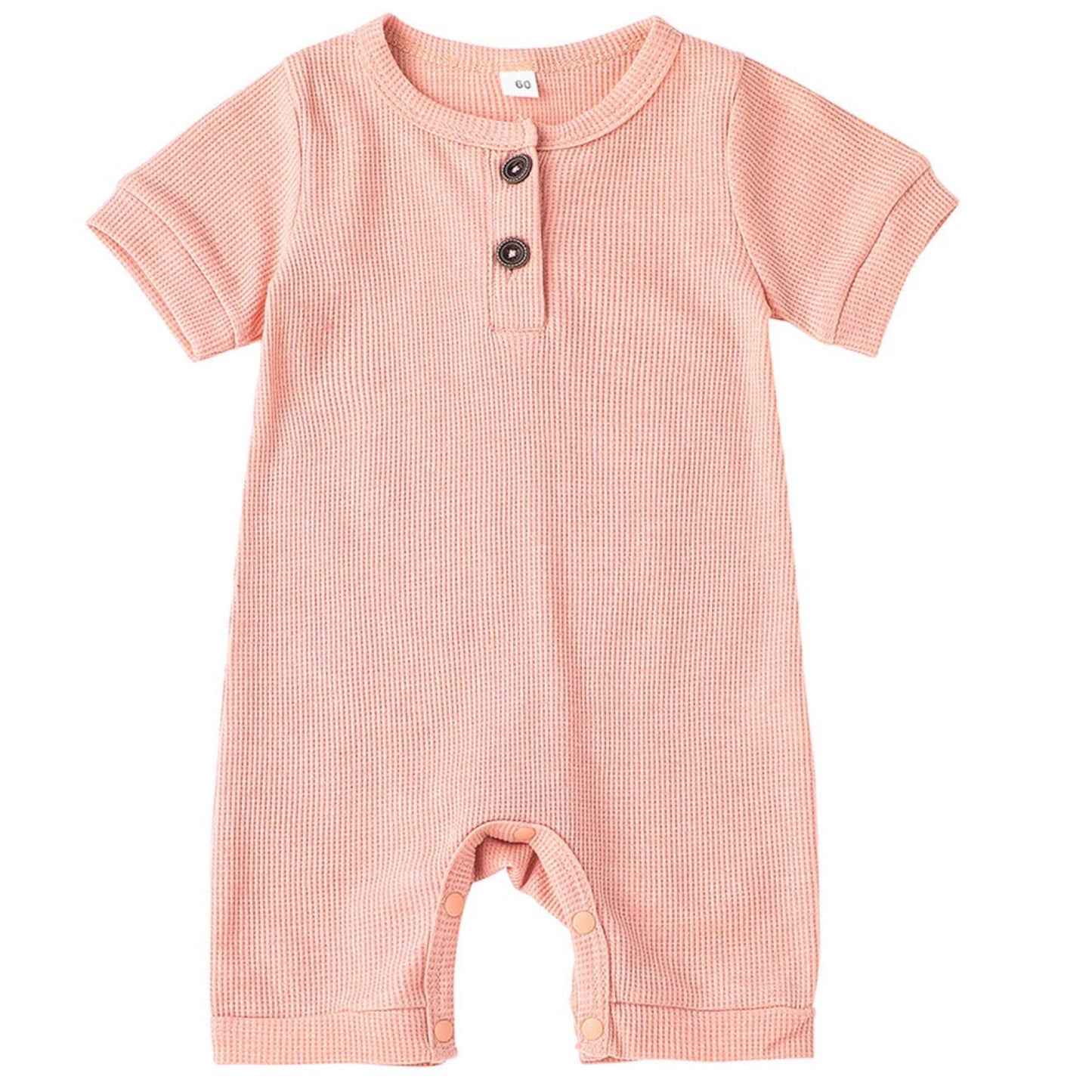 Flat lay of pink baby romper in waffle cotton fabric – summer baby outfit