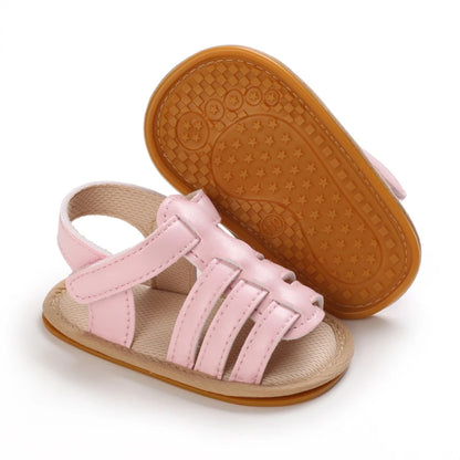 Pink Marlow baby fisherman sandals showing one shoe from above and the other turned sideways to display the flexible sole and adjustable Velcro strap | Pipp & Lola